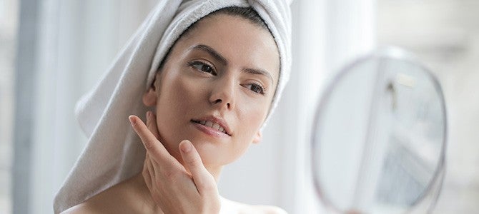 clean beauty_In-Article Image 01 woman looking into a mirror